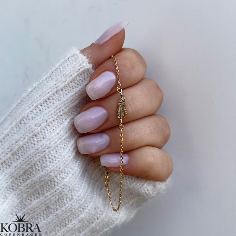 "Merle" gold bracelet with a small feather