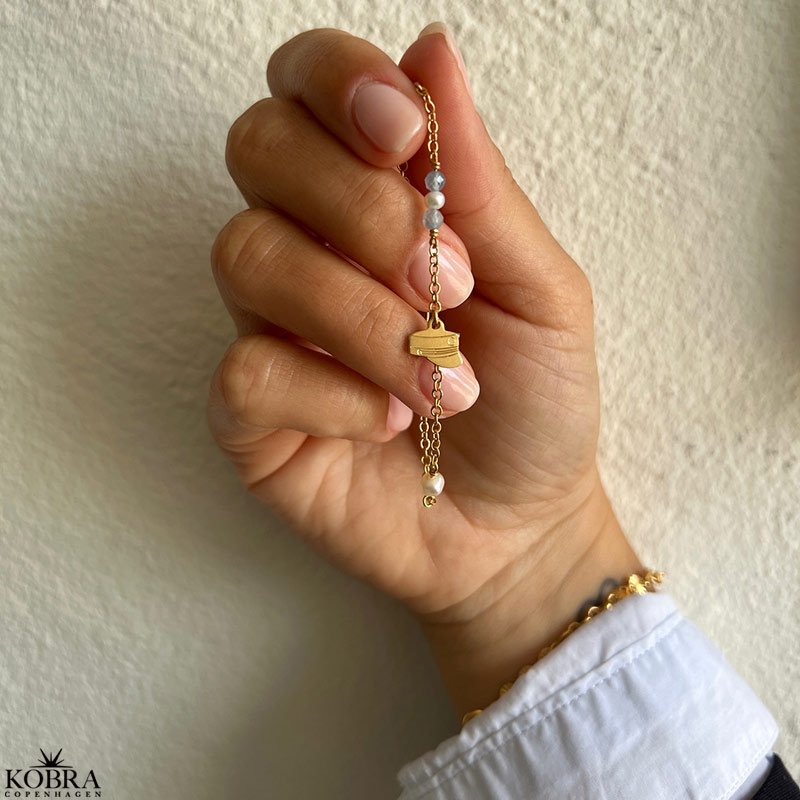 Studenter armbnd i guld med hue-vedhng og bl perler