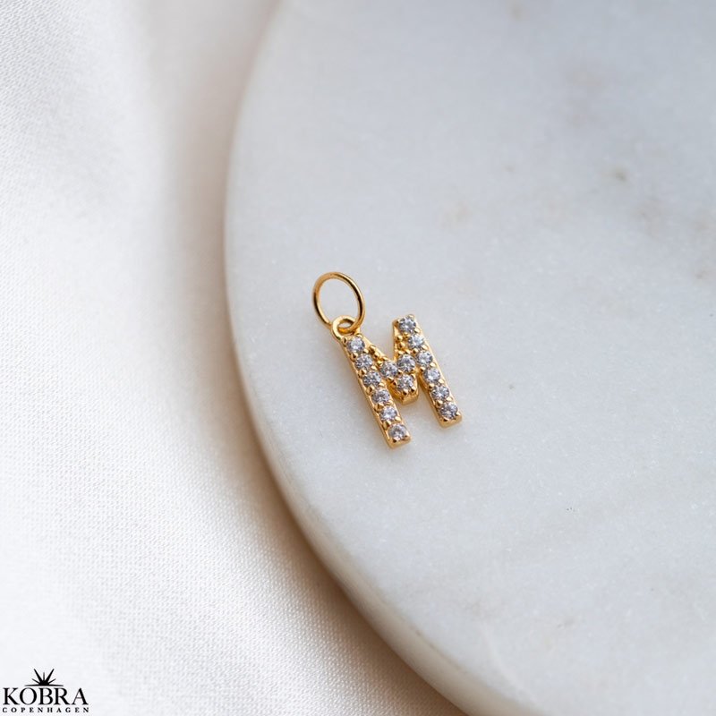 "Alias" gold letter with white stones (charm)