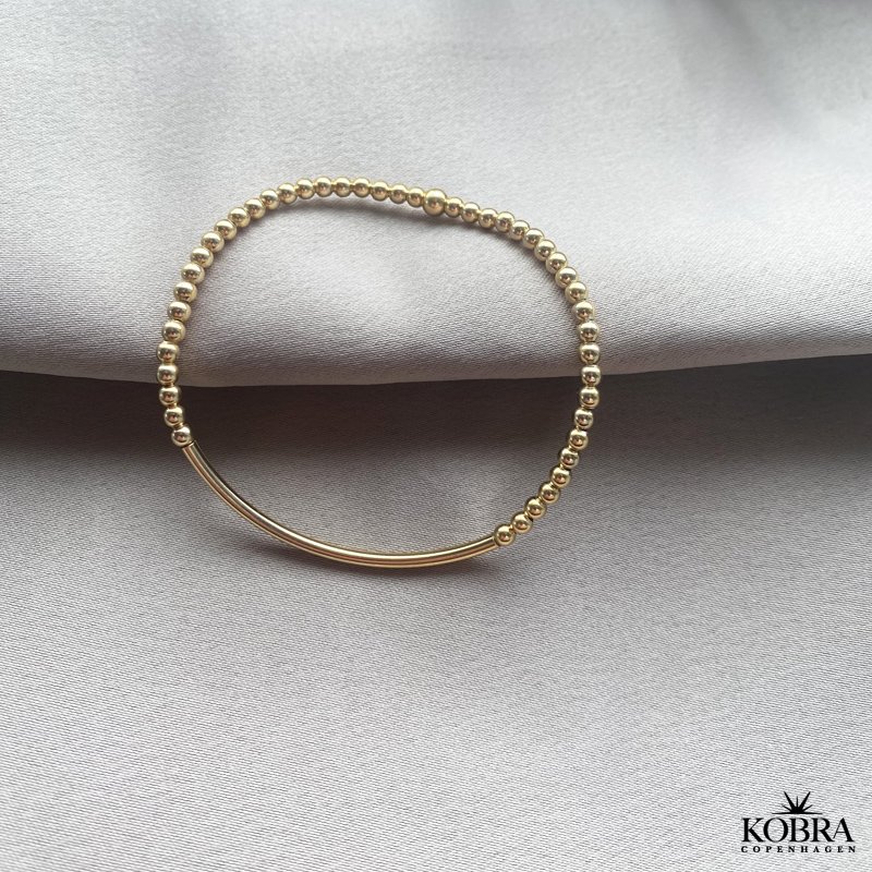 "Carly" Armbnd med bred plade og kraftige guldkugler