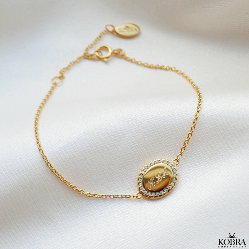 "Dazzling" guld armbnd med sten og gravering