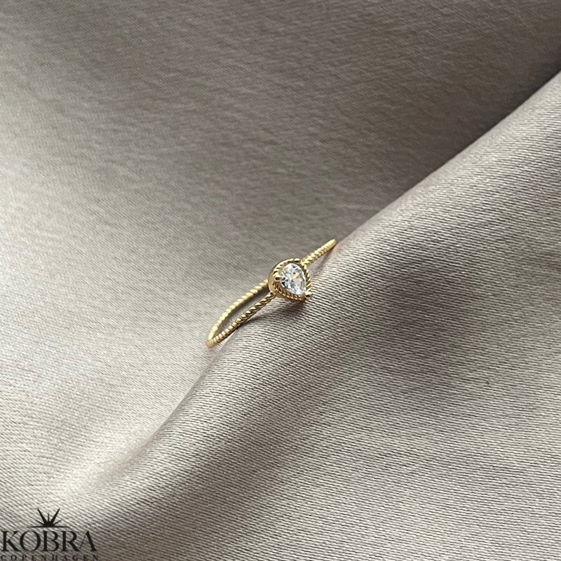 "Tillies" guld ring med drbeformet hvid sten