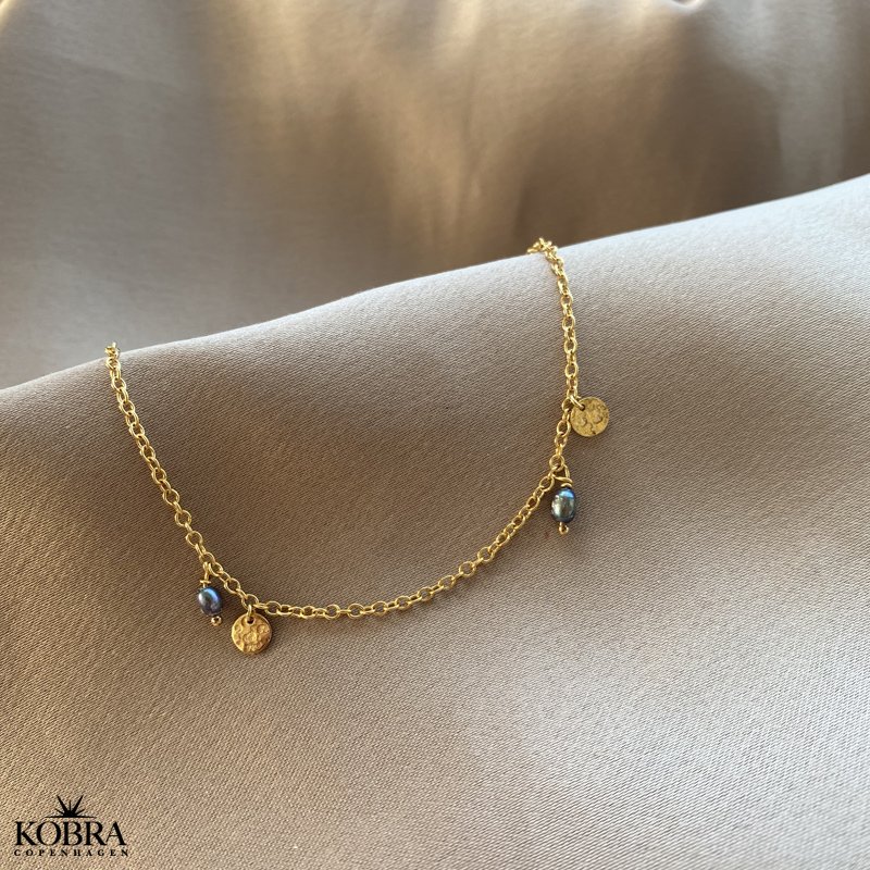 "Pittioni" guld ankelkde med bl ferskvandsperler og sm amuletter