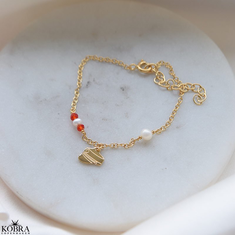 Studenter armbnd i guld med hue-vedhng og rde perler