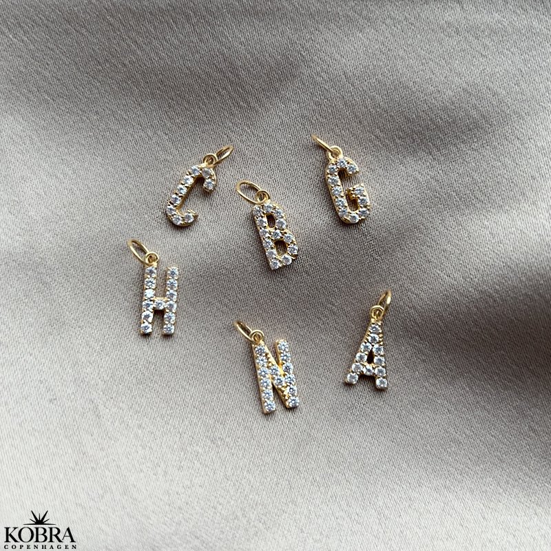 "Journal" guld amulet halskde med gravering samt bogstav med hvide sten