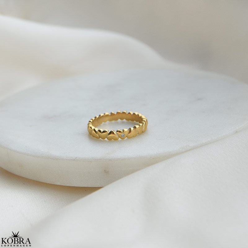 "Kaitlyn" guld ring med sm hjerter og en hvid sten