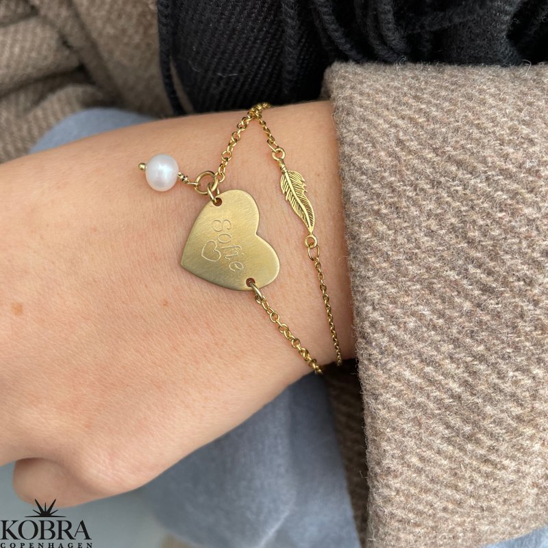 "Merle" gold bracelet with a small feather