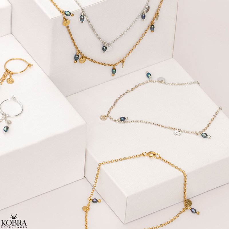 "Pittioni" guld ankelkde med bl ferskvandsperler og sm amuletter