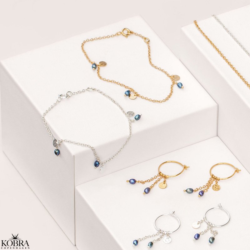 "Pittioni" guld reringe med bl ferskvandsperler og hammerslet amuletter