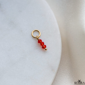 Charm i guld med 3 sm rde glasperler