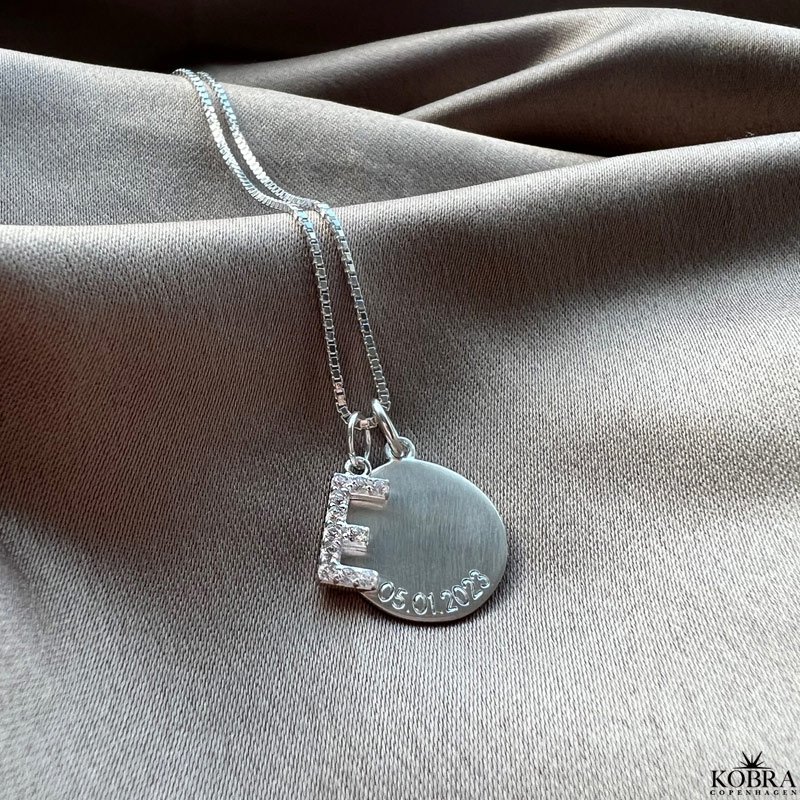 "Journal" slv amulet halskde med gravering samt bogstav med hvide sten