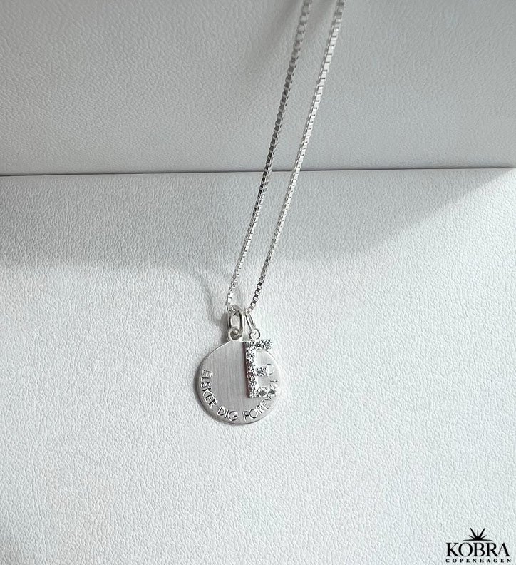 "Journal" slv amulet halskde med gravering samt bogstav med hvide sten