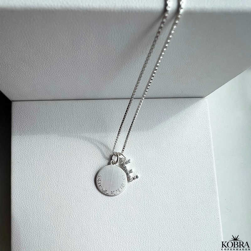 "Journal" slv amulet halskde med gravering samt bogstav med hvide sten