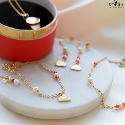 Studenter armbnd i guld med hue-vedhng og rde perler